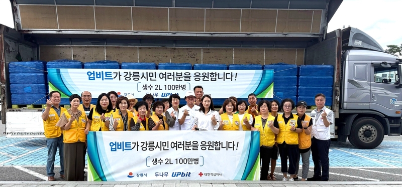 [사진자료2] 업비트가 강릉시에 생수 100만병을 기부, 대한적십자사 강릉지구봉사원 관계자들과 함께 기념 촬영을 하고 있다.